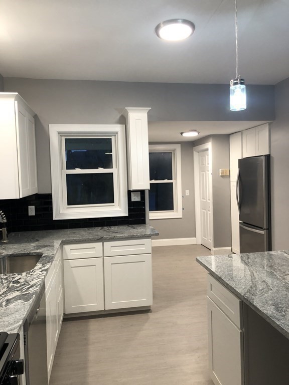 135 Winthrop Street Fall River, MA 02721 - Photo 12 of 26 a large kitchen with a stove and a sink