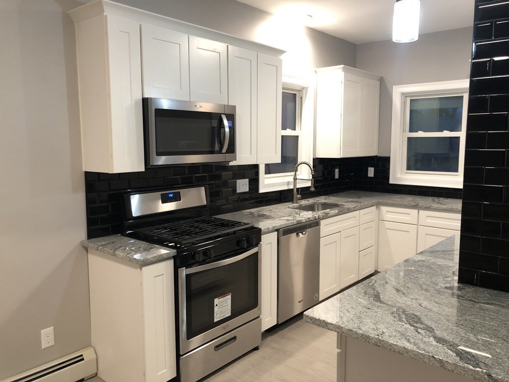 135 Winthrop Street Fall River, MA 02721 - Photo 13 of 26 a kitchen with granite countertop a stove and a sink