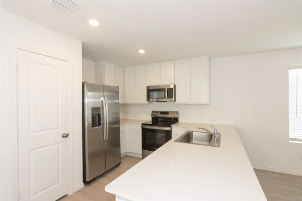 a kitchen with sink a microwave and cabinets