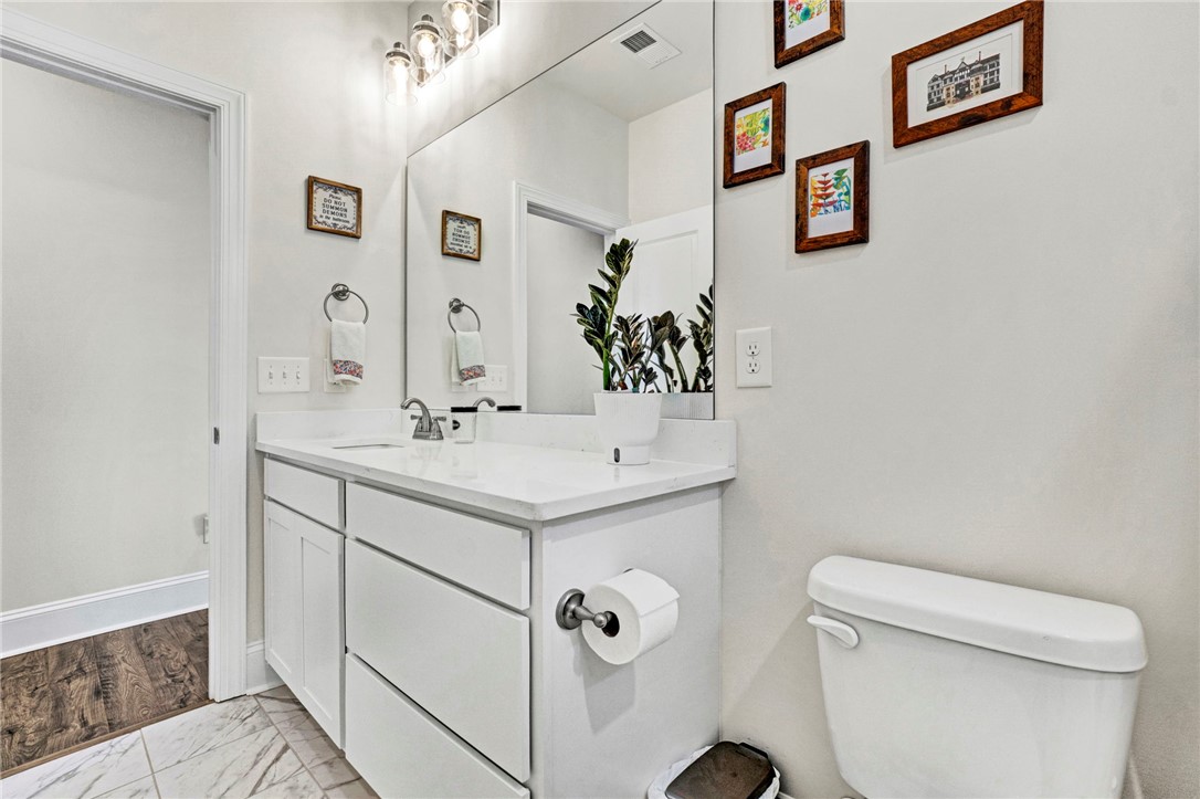 142 Juniper Hill Drive Easley, SC 29642 - Photo 34 of 47 This clean and bright bathroom features a single vanity, a toilet, and tasteful tiled flooring.