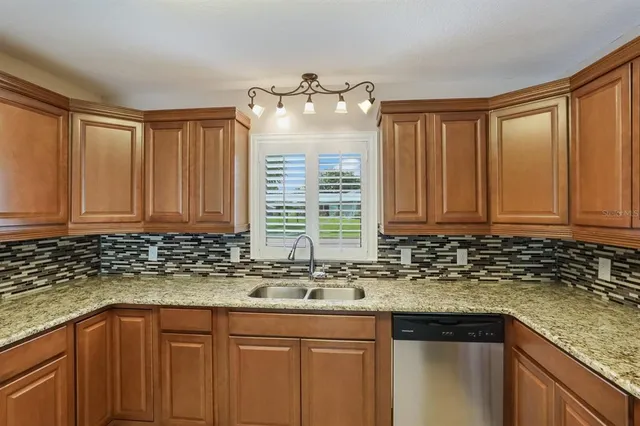 a kitchen with granite countertop a sink stainless steel appliances and a counter space