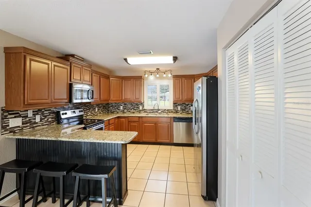 a large kitchen with granite countertop a sink and a refrigerator