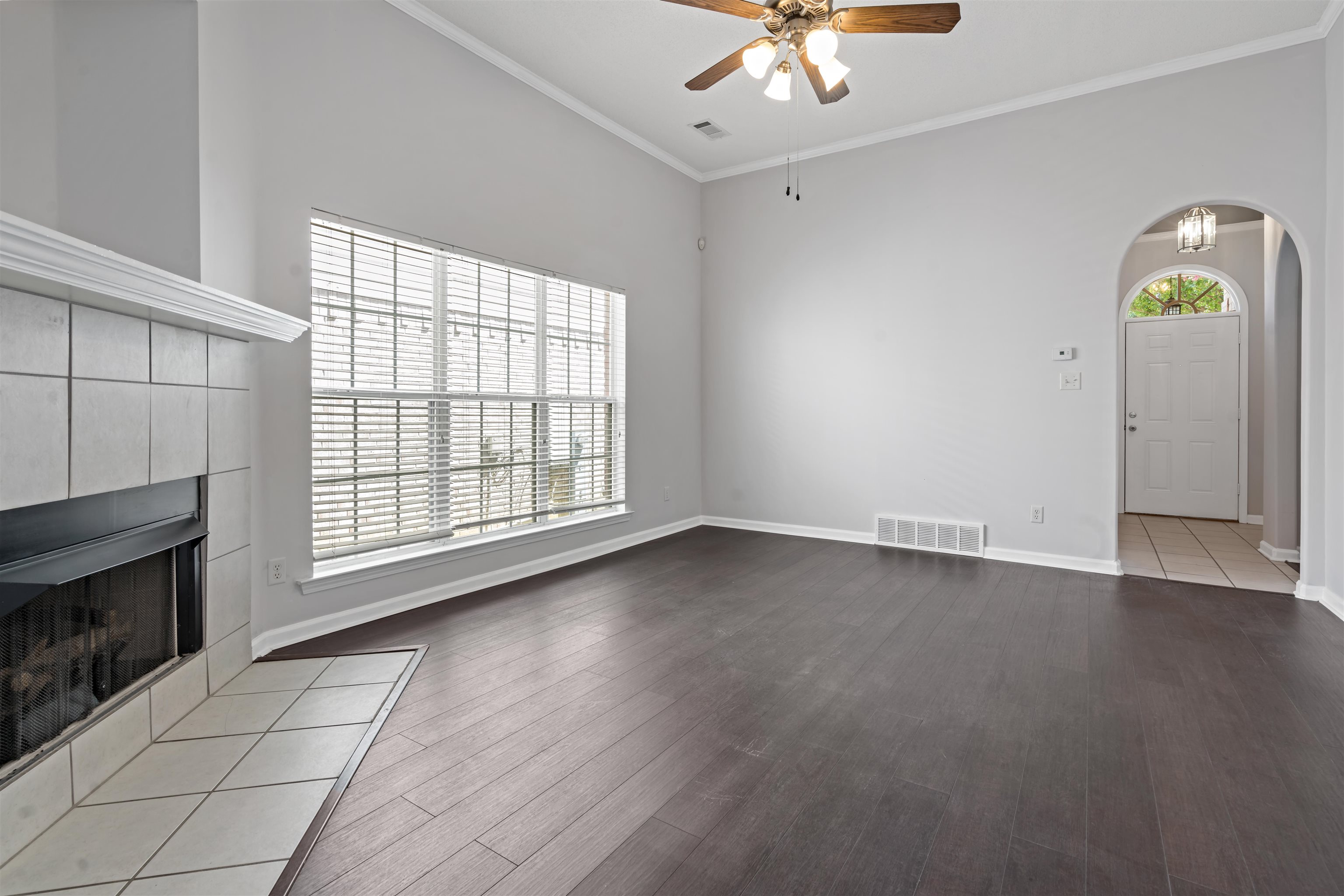 6814 Manslick Road Cordova, TN 38018 - Photo 4 of 20 Unfurnished living room with ceiling fan, a fireplace, ornamental molding, and wood-type flooring