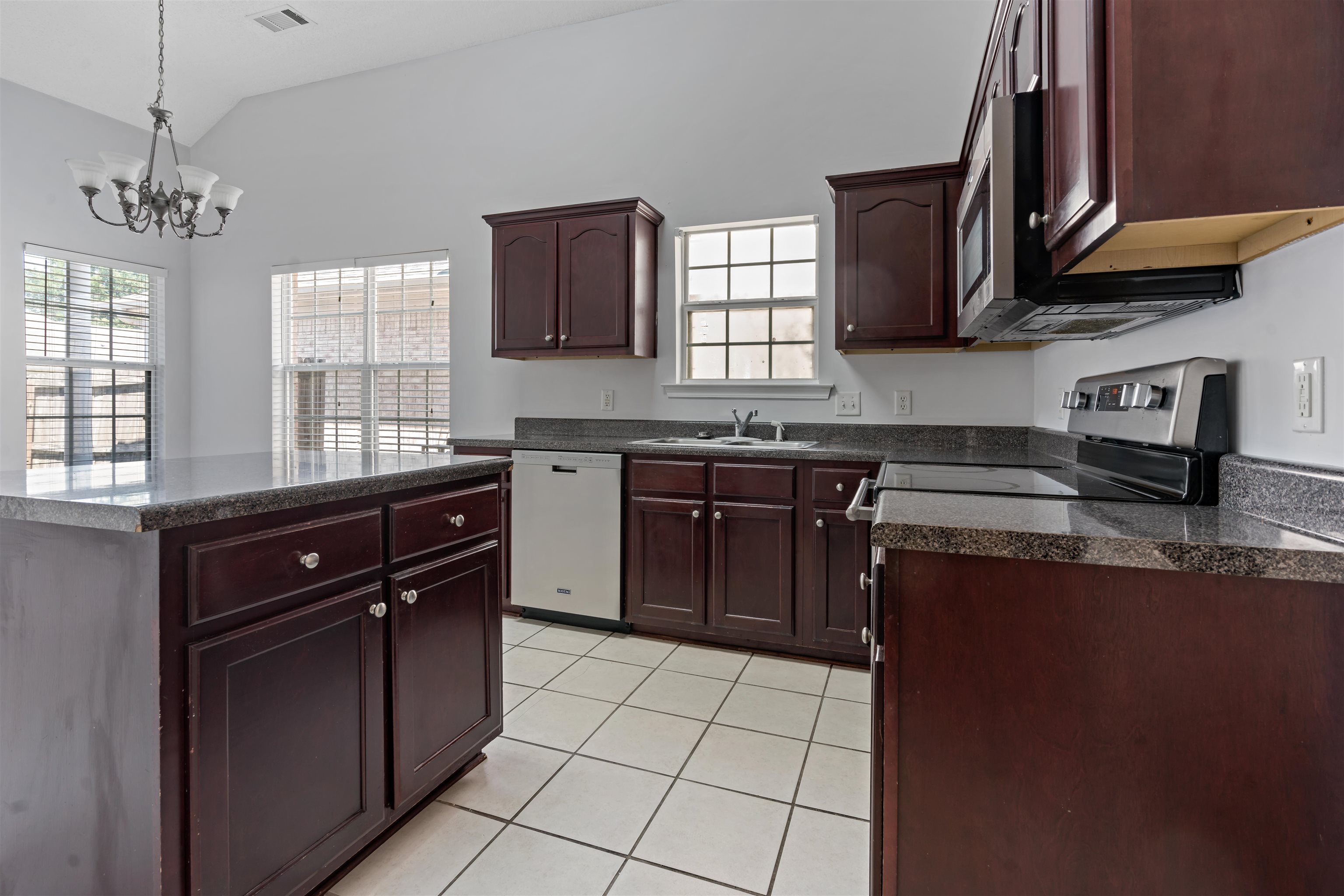 6814 Manslick Road Cordova, TN 38018 - Photo 5 of 20 Kitchen featuring an inviting chandelier, sink, light tile patterned floors, white dishwasher, and stove