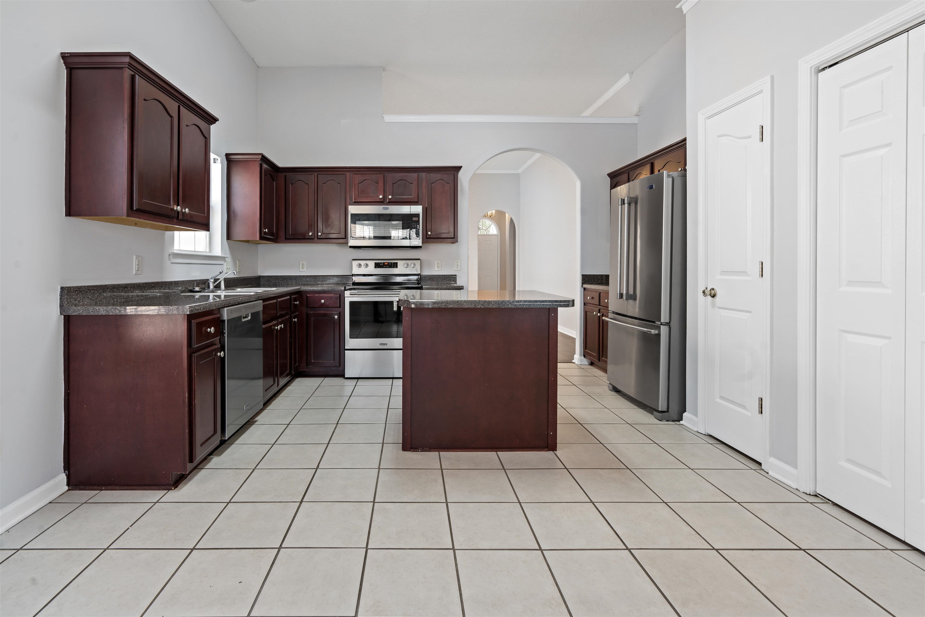 6814 Manslick Road Cordova, TN 38018 - Photo 6 of 20 Kitchen with light tile patterned flooring, appliances with stainless steel finishes, sink, and a kitchen island