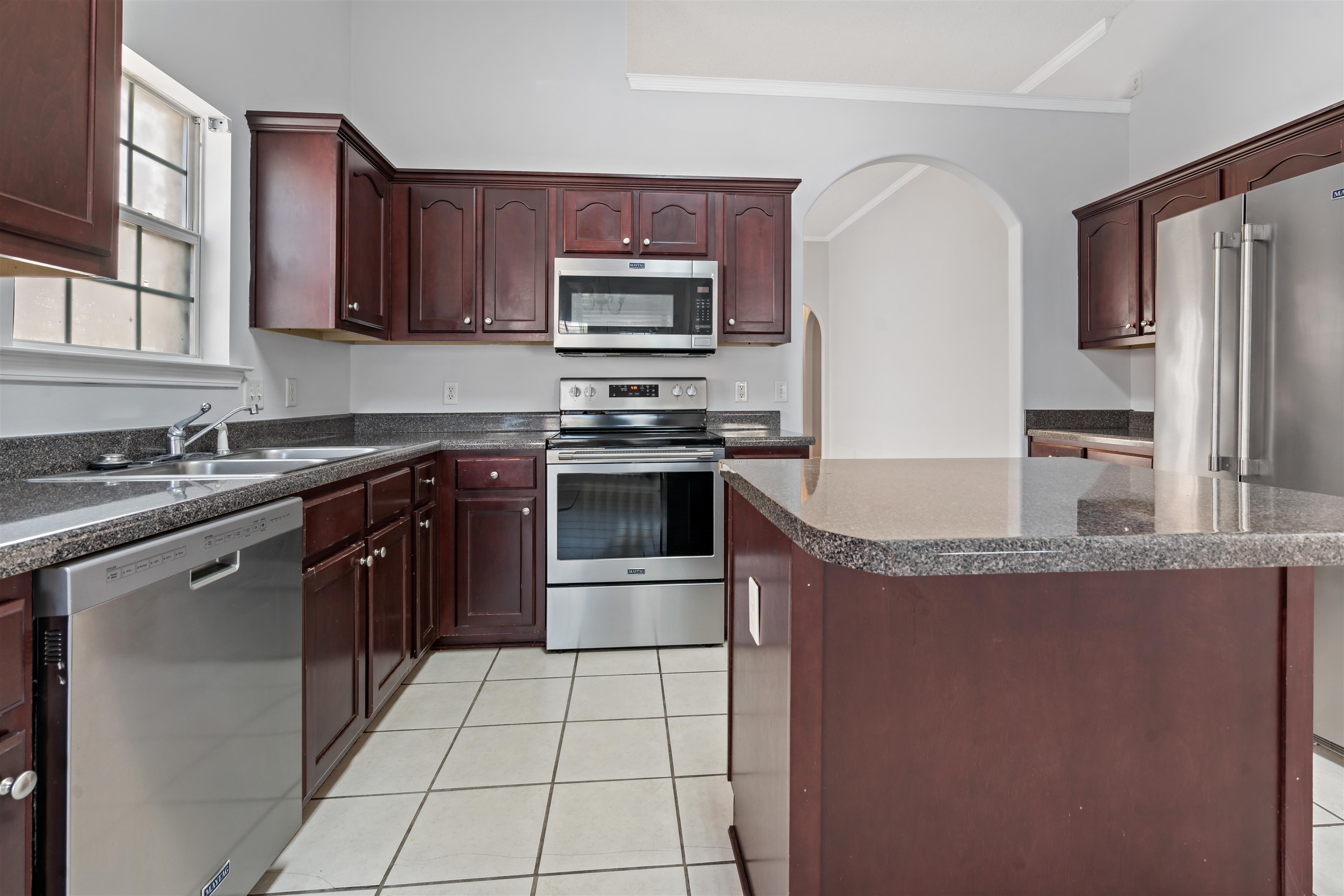 6814 Manslick Road Cordova, TN 38018 - Photo 7 of 20 Kitchen with a kitchen island, stainless steel appliances, ornamental molding, and light tile patterned floors