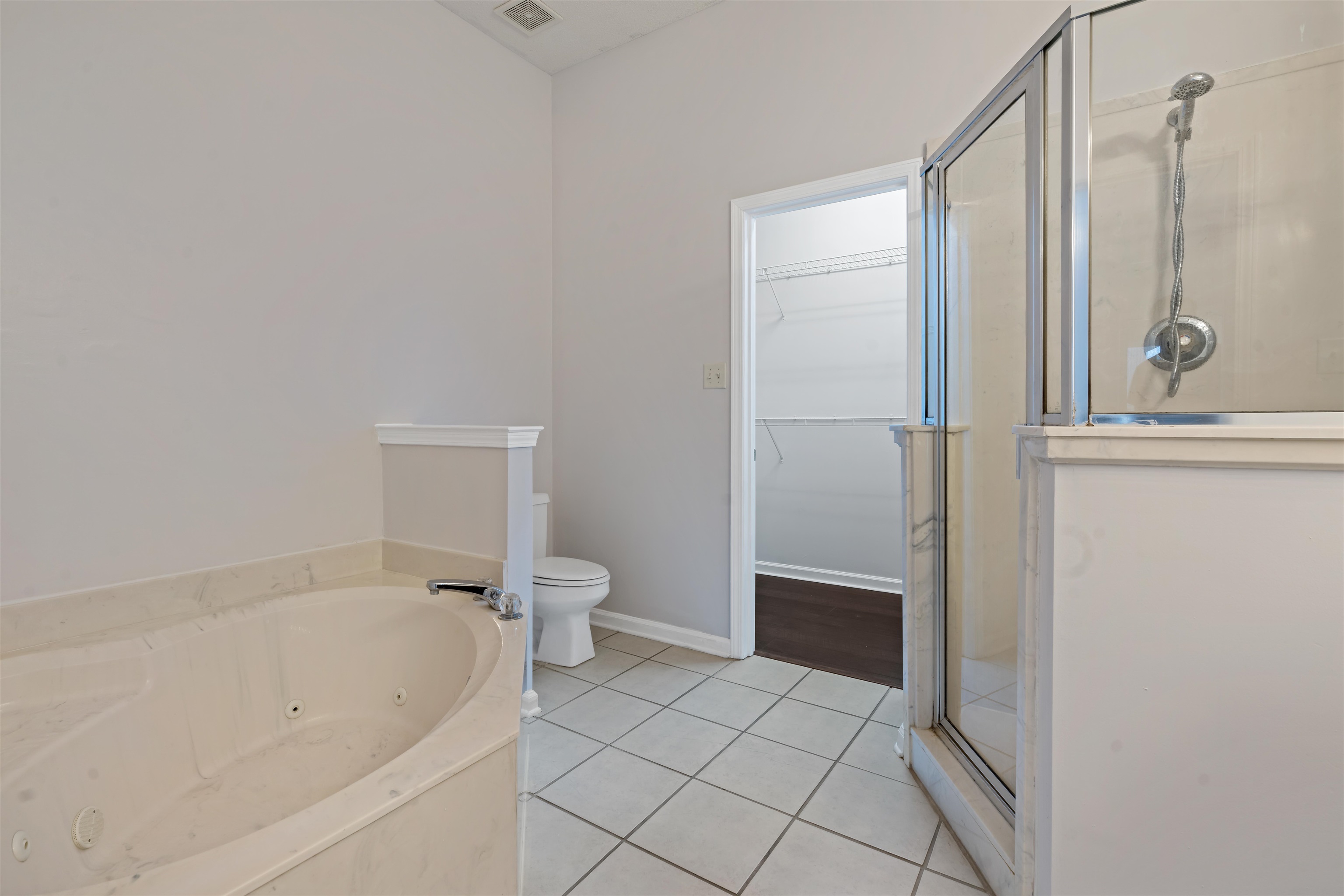 6814 Manslick Road Cordova, TN 38018 - Photo 10 of 20 Bathroom with hardwood / wood-style floors, toilet, and separate shower and tub