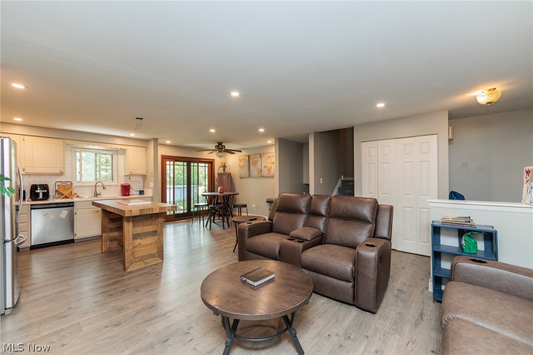 6065 Avon Belden Road North Ridgeville, OH 44039 - Photo 11 of 25 Open-concept living area featuring light wood-finish flooring, recessed lighting, and a kitchen with white cabinetry and stainless steel appliances