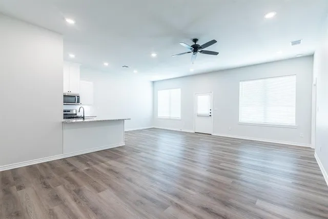 a view of a kitchen with a sink and wooden floor