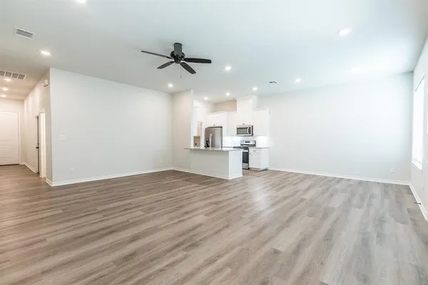 a large kitchen with stainless steel appliances granite countertop a lot of counter space and a sink
