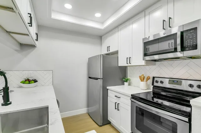 a kitchen with stainless steel appliances a stove a microwave and a refrigerator