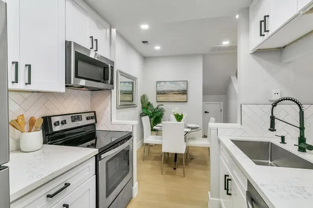 a kitchen with stainless steel appliances a stove a sink a microwave and cabinets