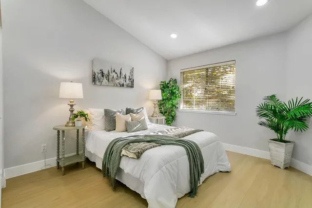 a bedroom with a bed and a potted plant