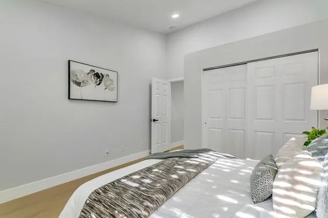 a bedroom with a bed and a painting on the wall