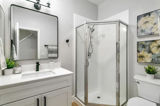 a bathroom with a shower sink vanity and mirror