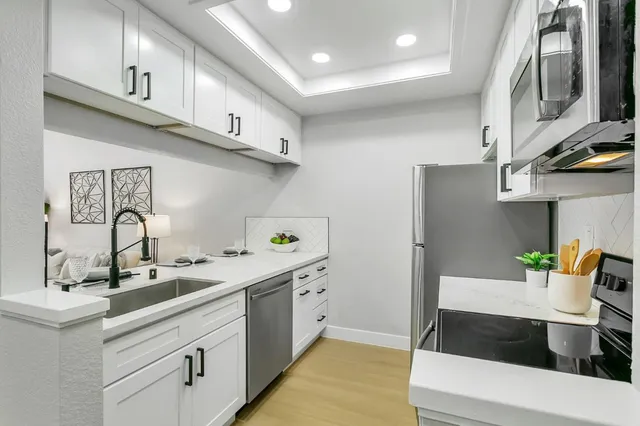 a kitchen with stainless steel appliances a sink and a refrigerator
