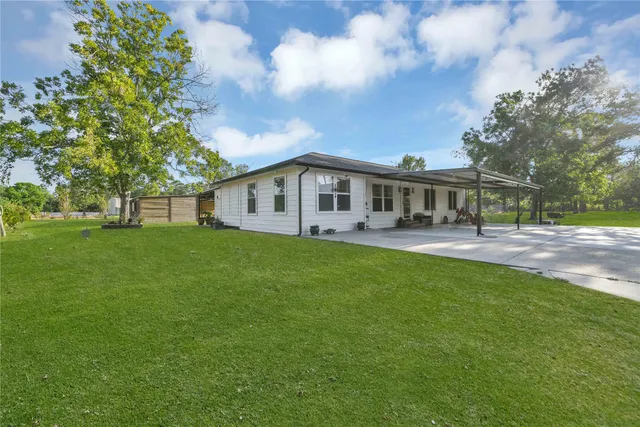 a living room with patio furniture and a garden