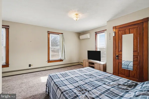 a bedroom with a large bed and a flat tv screen