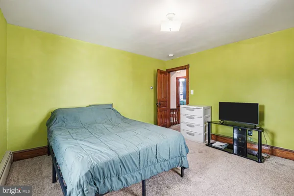 a bed sitting in a spacious bedroom next to a window