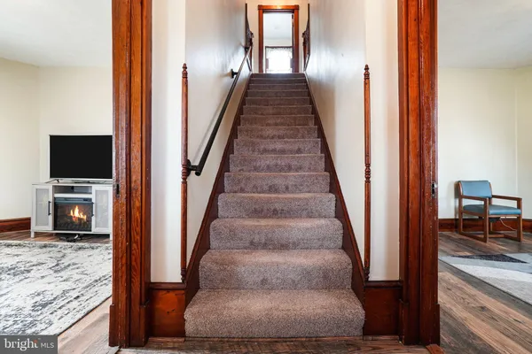 a view of a hallway with wooden floor and staircase