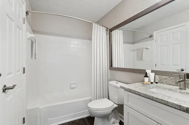 a bathroom with a granite countertop sink toilet and shower