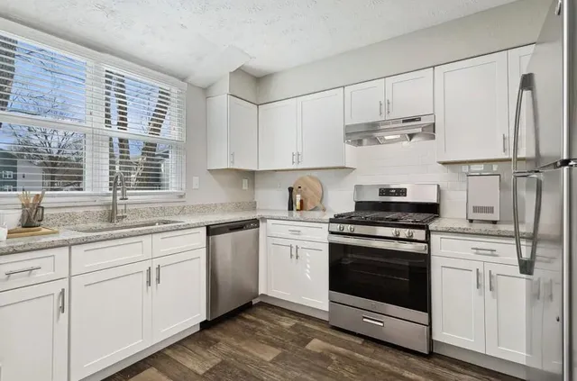 a kitchen with cabinets appliances and a sink