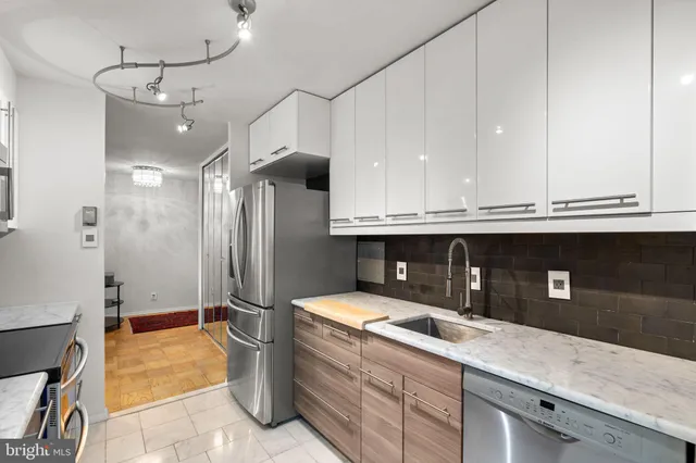 a kitchen with stainless steel appliances granite countertop a sink a stove and a refrigerator