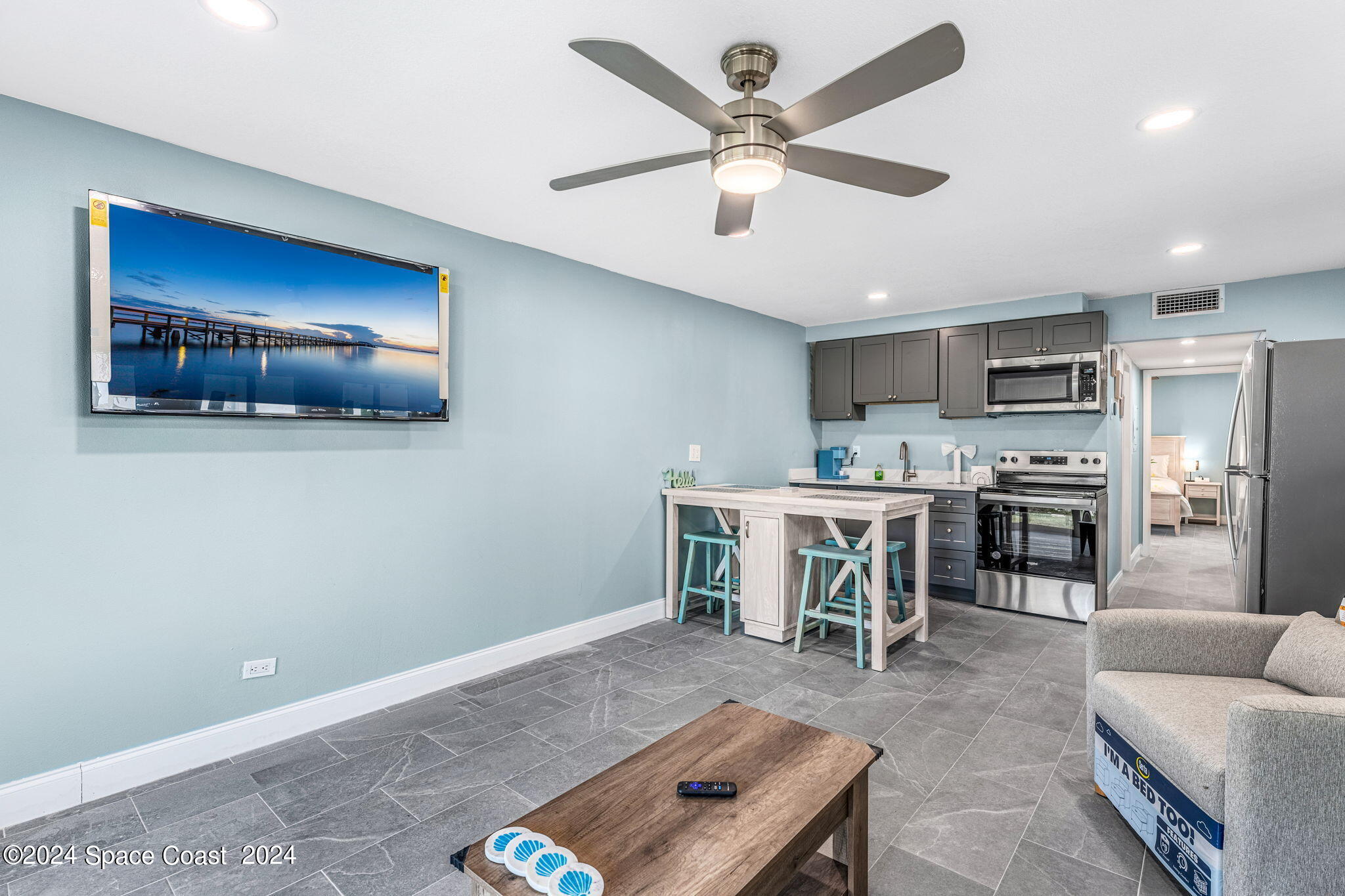 2189 Pineapple Avenue, Unit C Melbourne, FL 32935 - Photo 17 of 67 a living room with stainless steel appliances kitchen island granite countertop furniture and a wooden floor