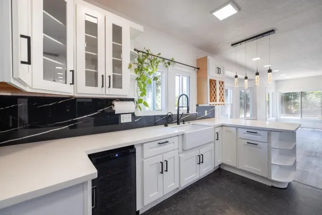 a kitchen with white cabinets and sink