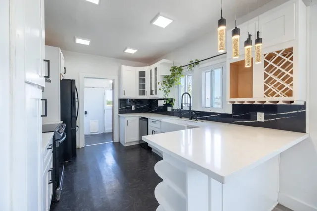 a large kitchen with stainless steel appliances a center island wooden floor and cabinets