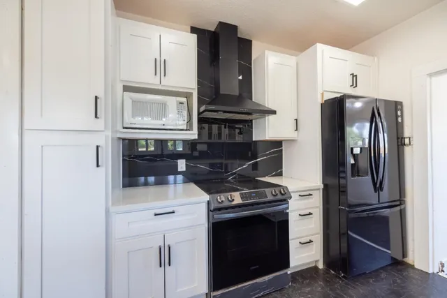 a kitchen with stainless steel appliances granite countertop a refrigerator stove and sink