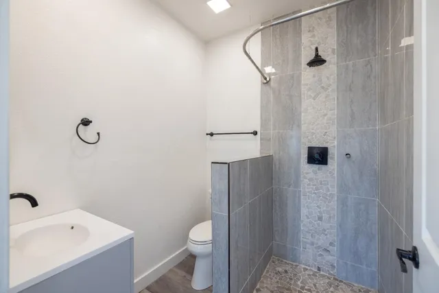 a bathroom with a sink a toilet and shower