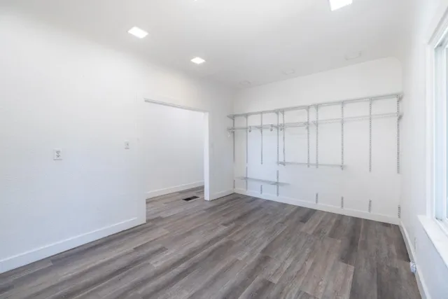 a view of an empty room with wooden floor