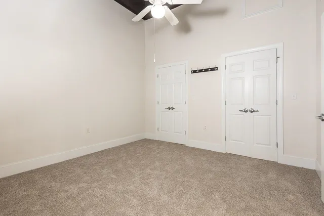an empty room with a ceiling fan and a window