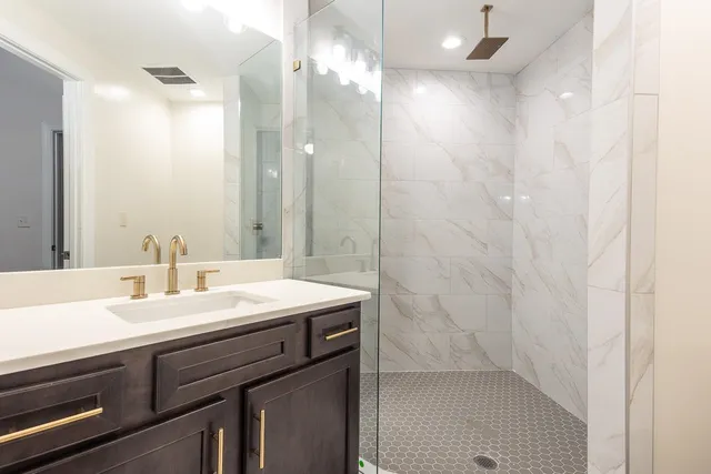 a bathroom with a sink a shower and a mirror