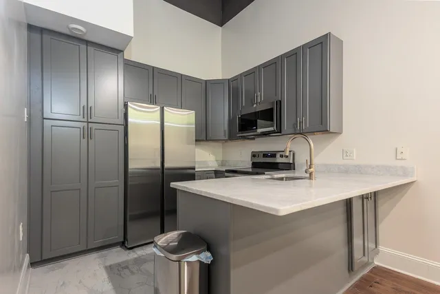 a kitchen with stainless steel appliances granite countertop a refrigerator a stove a sink and a microwave