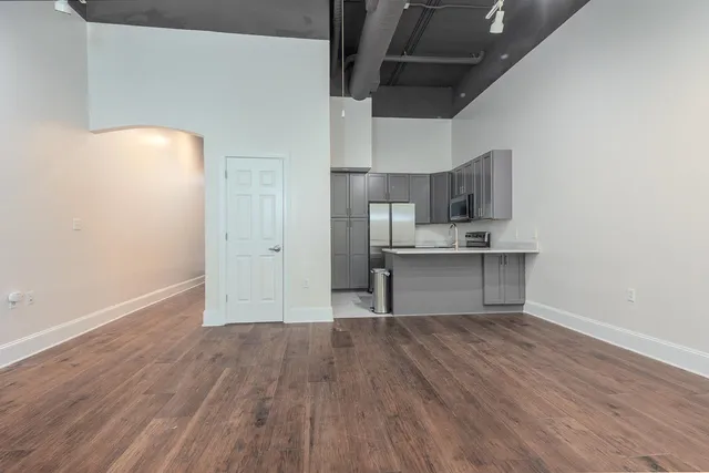 a kitchen with cabinets wooden floor and stainless steel appliances