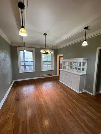 a view of an empty room with window and wooden floor