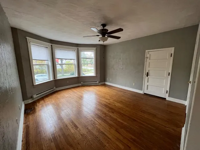 wooden floor in an empty room with a window