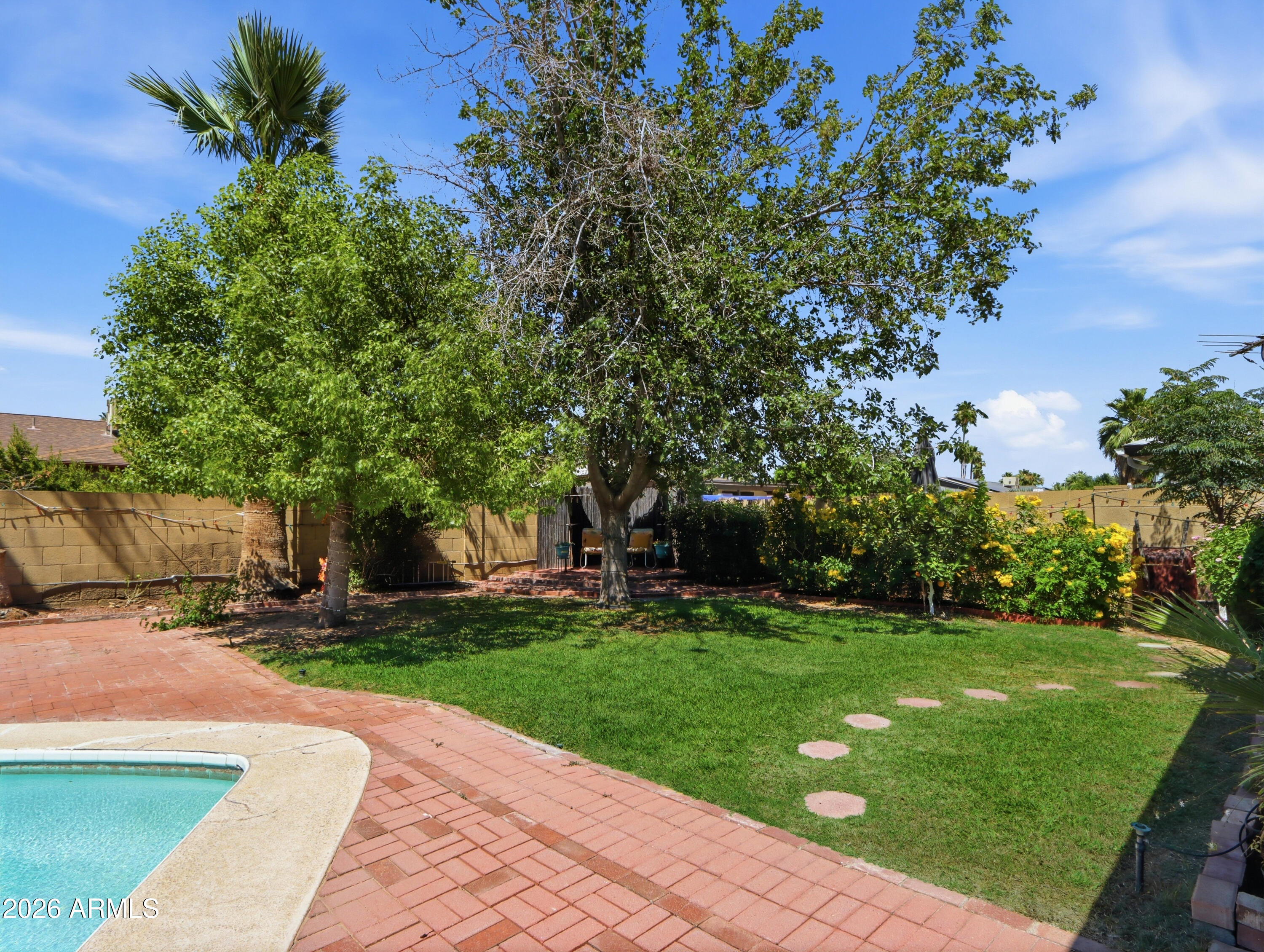 450 Cascada Road Litchfield Park, AZ 85340 - Photo 32 of 40 a backyard of a house with lots of green space and fountain
