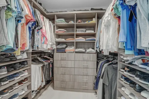 a bedroom with a large bed and a flat tv screen on dresser