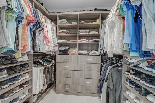 a bedroom with a large bed and a flat tv screen on dresser