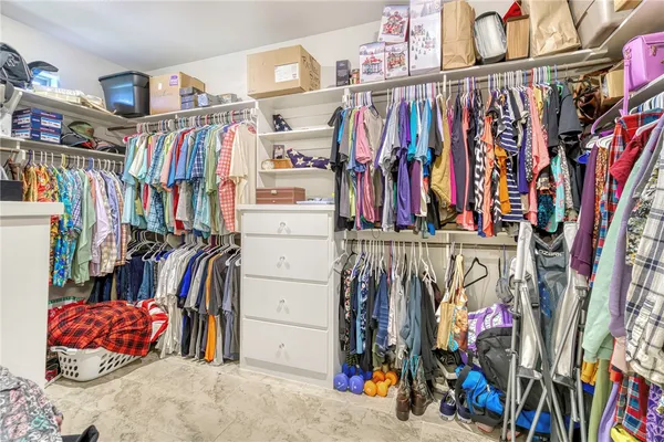 a view of walk in closet with clothes