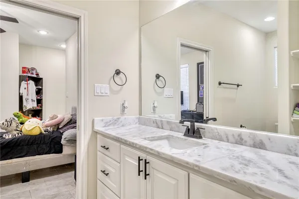 a bathroom with a granite countertop sink and a mirror