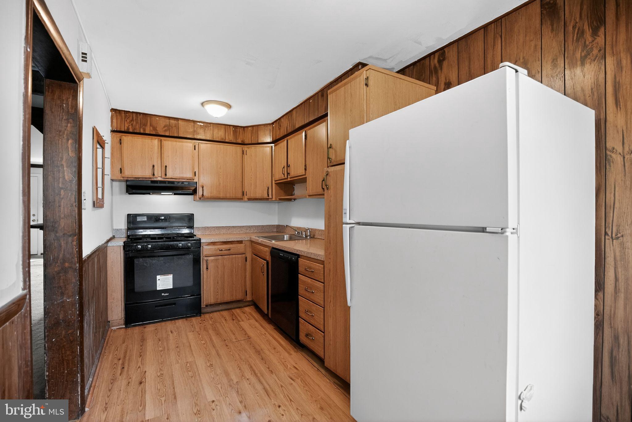 1403 Rainer Road Brookhaven, PA 19015 - Photo 11 of 25 a kitchen with a refrigerator a stove top oven and cabinets