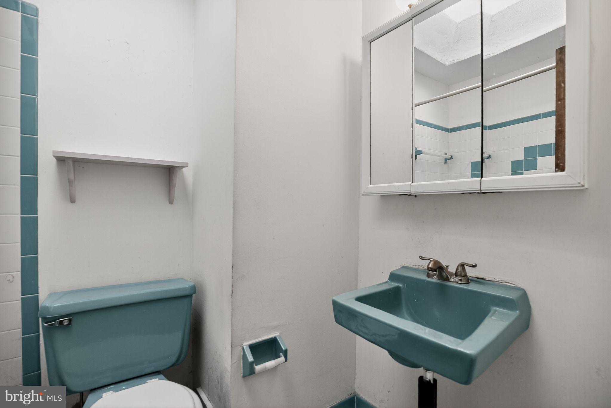 1403 Rainer Road Brookhaven, PA 19015 - Photo 19 of 25 a bathroom with a toilet sink and mirror