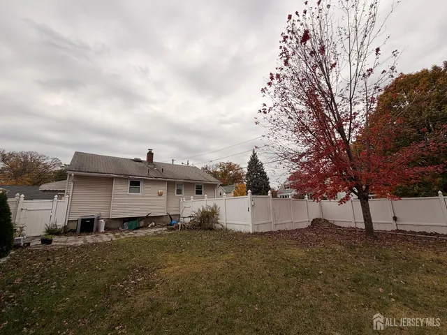a view of a white house with a big yard and large tree