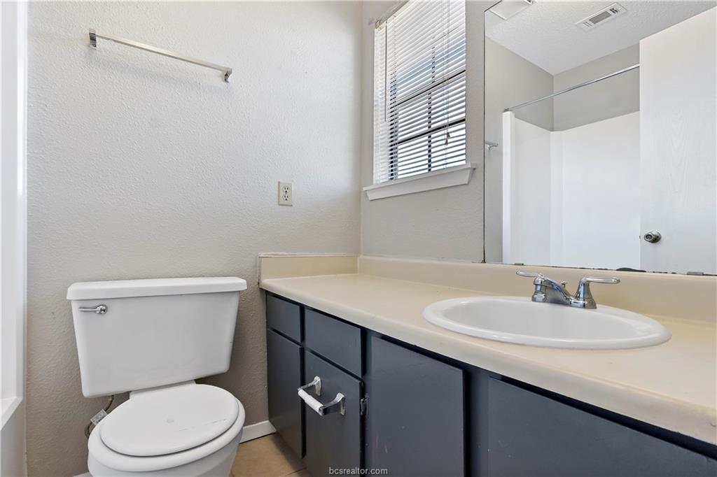 1112 Autumn Circle, Unit D College Station, TX 77840 - Photo 14 of 15 a bathroom with a sink a toilet and a mirror