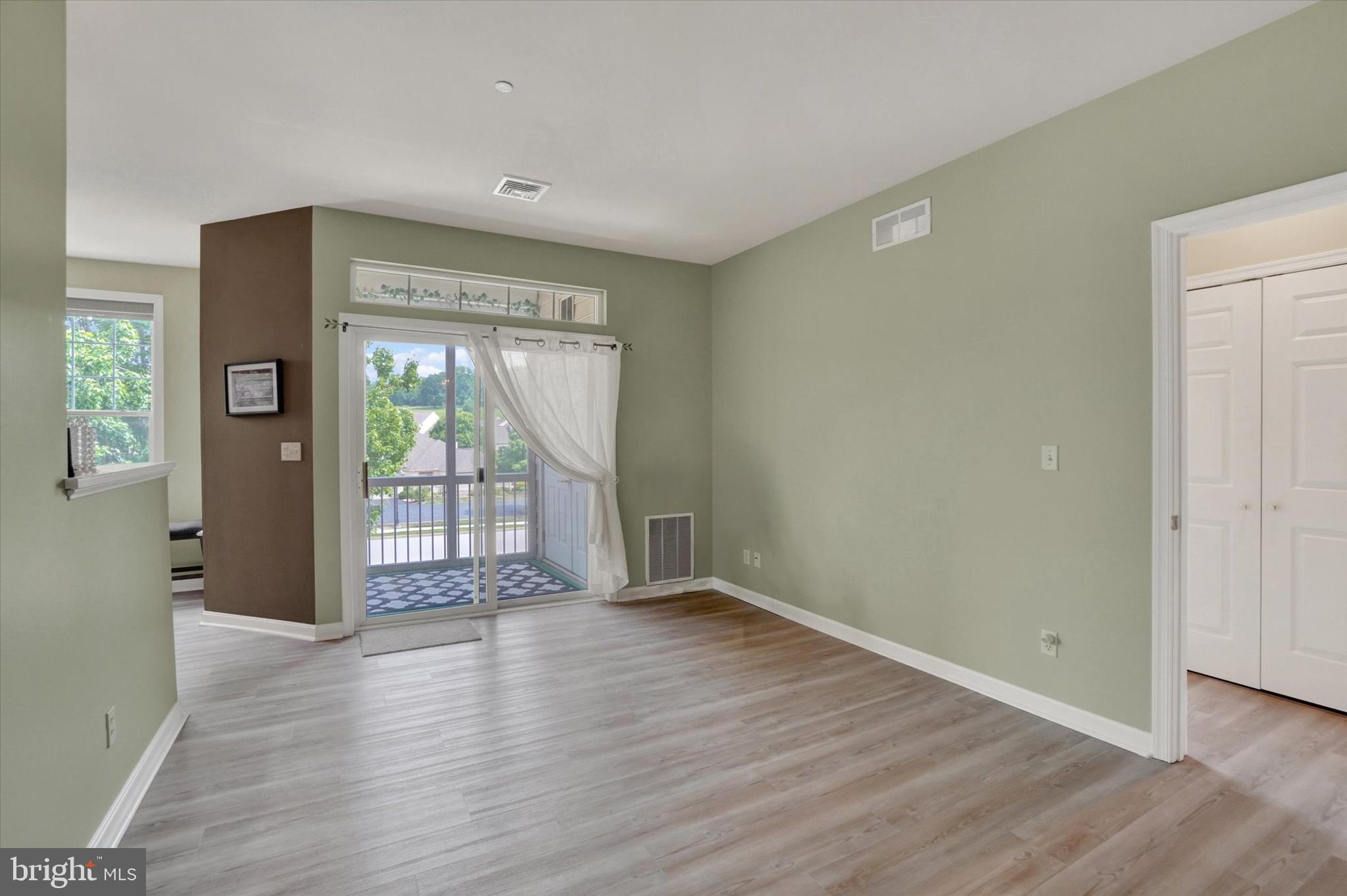 1010 Crest Way, Unit 304 York, PA 17403 - Photo 15 of 24 a view of an empty room with wooden floor and a window