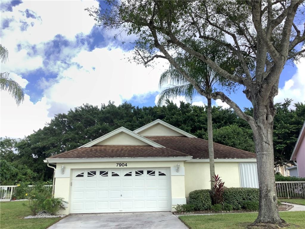 7904 Mansfield Hollow Road Delray Beach, FL 33446 - Photo 26 of 27 a front view of a house with a garden and tree